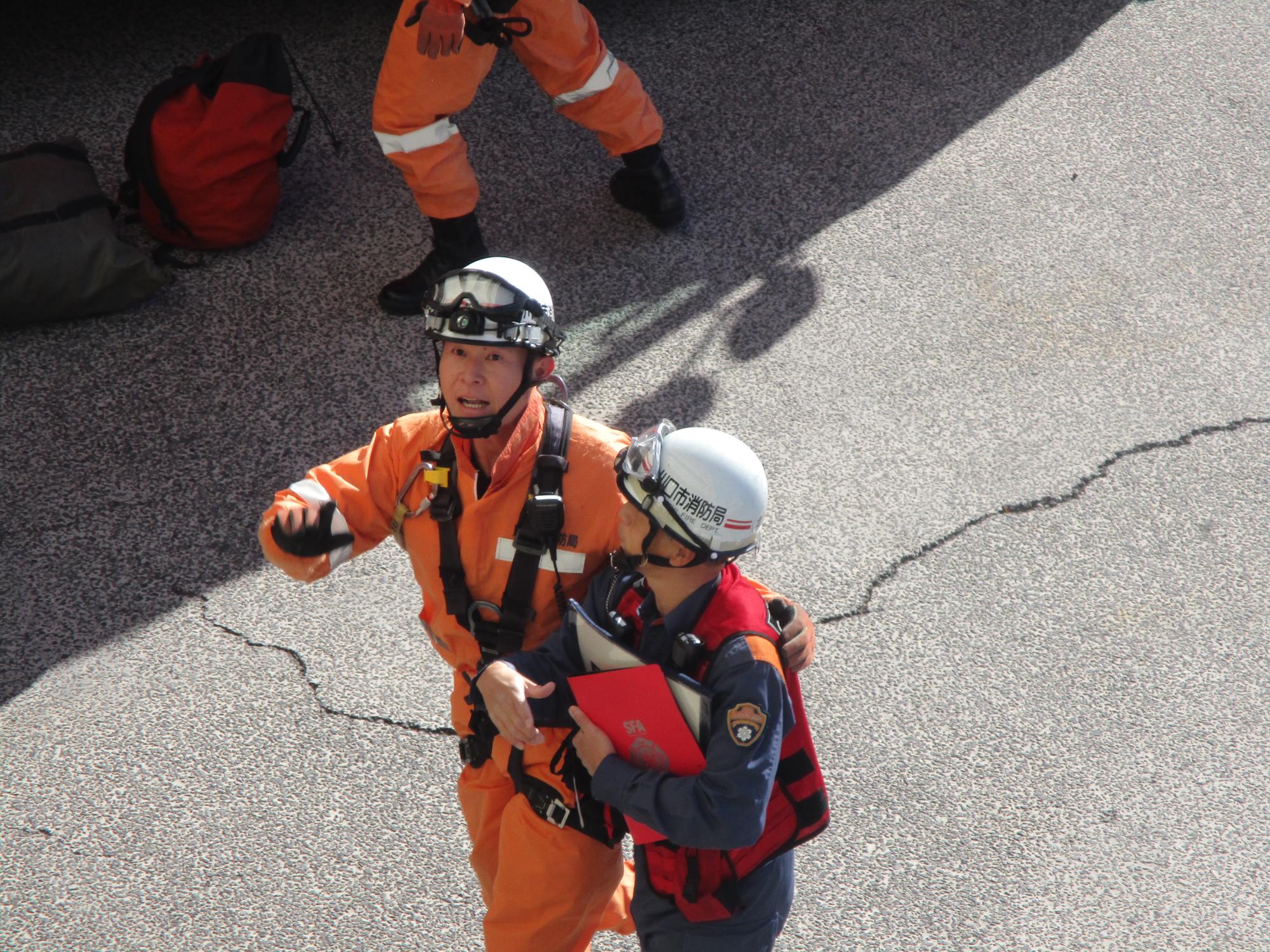 北消防署特別高度救助小隊長はこの災害の関係者と接触し作業員が転落した場所や建物構造について情報収集をします。