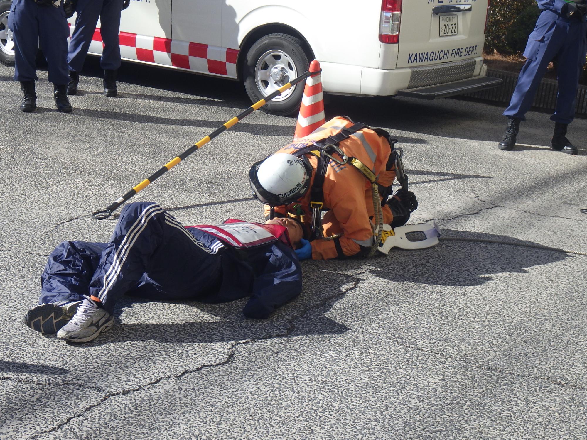 隊員は直ちに転落した作業員の意識、呼吸、負傷状況を観察し中2階にいる救助小隊長に状況を報告します。
