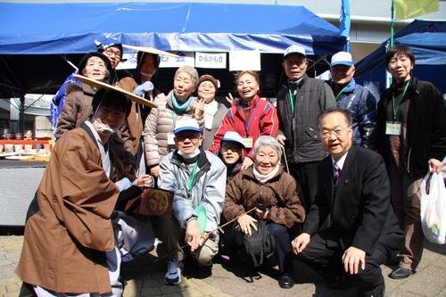 キュポ・ラ市場で来場者の皆さんと記念撮影をする市長の写真