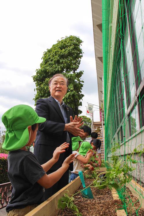 ゴーヤの苗植えをする市長の写真