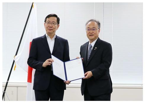 総務大臣代理の安田事務次官に申出書を渡す奥ノ木市長の写真
