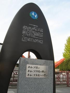 平和こそ尊い、平和こそ市民の願い、平和こそ未来への誓いと書かれた青空の下の平和記念碑の写真