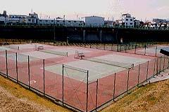 曇りの日にテニスコートのある毛長川庭球場の写真