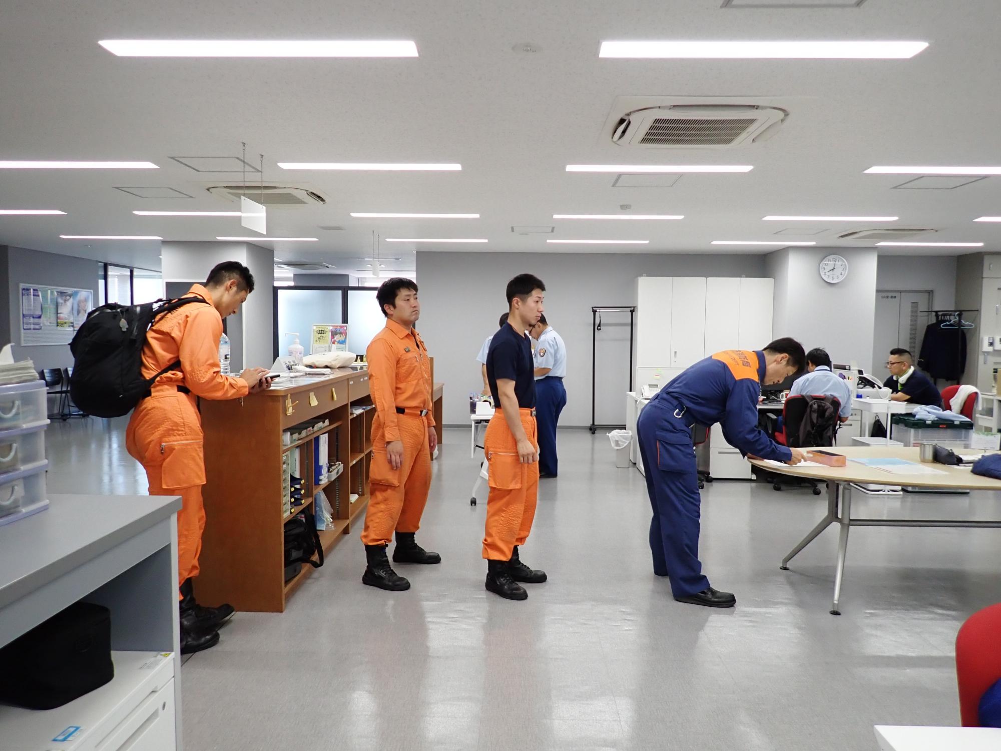 参集してきた職員が名前を記入するために並んでいる写真