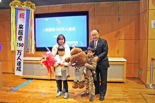 科学館来館者150万人達成セレモニーで150万人目の来館者と記念撮影をする市長の写真