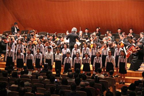 第34回川口市親と子の音楽会での合唱団とオーケストラの演奏の様子の写真